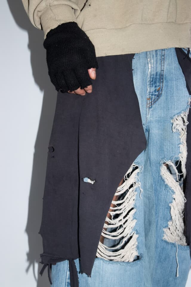 Distressed denim shorts close-up, hand and ripped detail